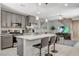 Spacious kitchen with gray cabinets, stainless steel appliances, and island seating overlooking the living area at 4537 Cloudrest Peak St, North Las Vegas, NV 89031