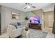 Inviting living room with comfortable seating, a fireplace, ceiling fan, and stairs at 4537 Cloudrest Peak St, North Las Vegas, NV 89031