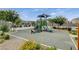Community playground with slide, green benches, and vibrant flowers, shaded by nearby trees at 4537 Cloudrest Peak St, North Las Vegas, NV 89031