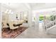 Open dining area with chandelier, piano and tile flooring, leading to living room and pool view at 454 Rosina Vista St, Las Vegas, NV 89138