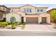 Inviting two-story home with a terracotta tile roof, manicured landscaping and brick paved driveway at 454 Rosina Vista St, Las Vegas, NV 89138