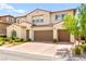 Beautiful two-story home with a terracotta tile roof, manicured landscaping and brick paved driveway at 454 Rosina Vista St, Las Vegas, NV 89138