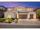 Inviting two-story home with a terracotta tile roof, manicured landscaping and brick paved driveway at 454 Rosina Vista St, Las Vegas, NV 89138