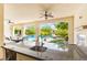 View of outdoor kitchen featuring granite countertops and stainless steel sink overlooking the refreshing pool and backyard at 454 Rosina Vista St, Las Vegas, NV 89138