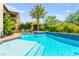 Beautiful pool area with a built-in spa, mature palm tree, and ample space for lounging at 454 Rosina Vista St, Las Vegas, NV 89138