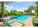 Inviting backyard oasis with a sparkling pool, spa, lush landscaping, and string lights perfect for relaxation at 454 Rosina Vista St, Las Vegas, NV 89138