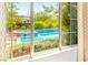 A clear view through windows reveals the backyard pool, surrounded by manicured greenery for outdoor enjoyment at 454 Rosina Vista St, Las Vegas, NV 89138
