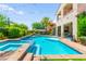 Backyard features a stunning pool with a spa, lounge area, and lush landscaping at 454 Rosina Vista St, Las Vegas, NV 89138