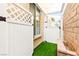 Charming side yard featuring artificial turf, white lattice fencing, and a cozy bench at 454 Rosina Vista St, Las Vegas, NV 89138