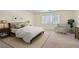 Bright bedroom featuring a comfortable bed, neutral carpeting, and a sunlit window at 4744 Deer Forest Ave, Las Vegas, NV 89139