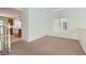 Versatile bonus room with neutral carpet, large window, and view of the kitchen at 4744 Deer Forest Ave, Las Vegas, NV 89139