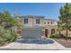 Two-story home featuring a 2-car garage, stone accents and neutral colored stucco with professionally landscaped yard at 4744 Deer Forest Ave, Las Vegas, NV 89139