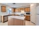 Traditional kitchen featuring wood cabinetry, white appliances and white tile countertops, backsplash and island at 4744 Deer Forest Ave, Las Vegas, NV 89139