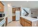 Traditional kitchen featuring wood cabinets and white appliances and tile countertops with an adjacent stairway at 4744 Deer Forest Ave, Las Vegas, NV 89139