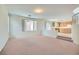 Spacious living room area showcasing a view of the kitchen, neutral carpet and paint, and natural light at 4744 Deer Forest Ave, Las Vegas, NV 89139