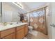 Bathroom featuring a single vanity, decorative mirror, and a shower-tub combo with decorative curtain at 4883 Grey Mesa St, Las Vegas, NV 89149
