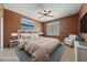 Bedroom with a queen bed, ceiling fan, artwork and chair near a window at 4883 Grey Mesa St, Las Vegas, NV 89149