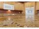 Close up of granite countertop with cabinets, oven, and microwave in the background at 4883 Grey Mesa St, Las Vegas, NV 89149