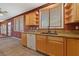 Kitchen with sink, faucet, windows with blinds, countertop, dishwasher, and view to living area at 4883 Grey Mesa St, Las Vegas, NV 89149