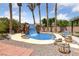 Backyard pool with rock waterfall feature, surrounded by palm trees and desert landscaping at 4883 Grey Mesa St, Las Vegas, NV 89149