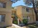 Exterior of multi-level home featuring stairs to front doors, multiple windows and manicured landscaping at 5155 W Tropicana Ave # 2140, Las Vegas, NV 89103