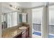 Bright bathroom with granite countertops, dark wood cabinets, and a shower-tub combo at 5166 S Jones Blvd # 205, Las Vegas, NV 89118