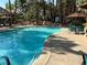 Sparkling community pool with tables and chairs around the concrete deck and palm trees in the background at 5222 Mandalay Springs Dr # 202, Las Vegas, NV 89120