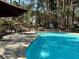 Inviting community pool with clear blue water, seating areas, and lush tropical landscaping at 5222 Mandalay Springs Dr # 202, Las Vegas, NV 89120
