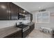 Kitchen features granite countertops, dark wood cabinets, and stainless appliances at 5966 Icicle Falls Ave, Las Vegas, NV 89130