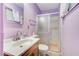 Charming bathroom featuring a sliding glass shower door, white toilet, and wood vanity at 601 Huntington St, Las Vegas, NV 89107