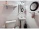 Bathroom featuring a pedestal sink and toilet, with a round mirror, and overhead lighting at 601 Huntington St, Las Vegas, NV 89107