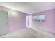Spacious bedroom with lilac walls, carpeted floor, and a large window at 601 Huntington St, Las Vegas, NV 89107