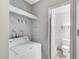 A simple laundry room with a stacked washer/dryer and a doorway to an adjacent bathroom at 601 Huntington St, Las Vegas, NV 89107