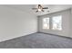 This bedroom has carpet floors, two large windows and a ceiling fan at 6117 Daisy Lee Ave, Las Vegas, NV 89108