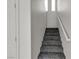 Bright staircase features carpeted steps, white walls, and natural light from the window at 6117 Daisy Lee Ave, Las Vegas, NV 89108