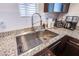 Close up on sink features granite countertop with stainless steel sink and modern fixtures at 6819 Citron Mist Ct, North Las Vegas, NV 89086