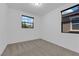 A bright bedroom with carpet flooring features two windows at 69 Ella Ashman Ave, Henderson, NV 89011