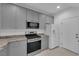A modern kitchen featuring gray cabinets, granite countertops, and stainless steel appliances at 69 Ella Ashman Ave, Henderson, NV 89011