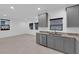 A modern kitchen featuring gray cabinets, granite countertops, and stainless steel appliances at 69 Ella Ashman Ave, Henderson, NV 89011