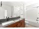 Modern bathroom boasts a double sink vanity with wood cabinets and a shower over tub at 6901 Whisper Canyon Pl, North Las Vegas, NV 89084