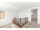 Upstairs landing featuring carpet and natural light, with wood railing and views into other rooms at 6901 Whisper Canyon Pl, North Las Vegas, NV 89084