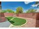 Private backyard featuring artificial turf, a picnic table, and a seating area, perfect for outdoor relaxation at 7372 S Palo Real Ct, Las Vegas, NV 89179
