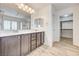 Bright bathroom with double sinks, wooden cabinetry, and a large mirror at 7372 S Palo Real Ct, Las Vegas, NV 89179