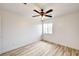 Bright bedroom with a ceiling fan, window, white walls, and light wood-look flooring at 7372 S Palo Real Ct, Las Vegas, NV 89179
