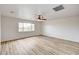 Large bedroom with a ceiling fan, wood-look flooring and a bright window at 7372 S Palo Real Ct, Las Vegas, NV 89179