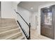 View of a hardwood stairway, featuring modern railing, leading to the entry door with decorative glass at 7372 S Palo Real Ct, Las Vegas, NV 89179