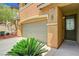 Close up of a garage and entryway, complimented by well manicured landscaping at 7372 S Palo Real Ct, Las Vegas, NV 89179