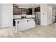 Modern eat in kitchen with dark wood cabinets and a white kitchen island at 7372 S Palo Real Ct, Las Vegas, NV 89179
