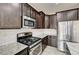 Modern kitchen with stainless steel appliances, granite countertops, and wood cabinets at 7372 S Palo Real Ct, Las Vegas, NV 89179