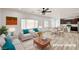 Bright, staged living room with wood floors, ceiling fan, and a view to the open kitchen at 7372 S Palo Real Ct, Las Vegas, NV 89179